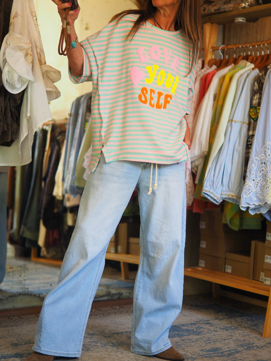 Blouse ample à rayures turquoise et rose, avec message coloré fluo “Love Your Self”( caoutchouc). Coupe loose et confortable, parfait pour un look casual et tendance.
Taille unique du 36 au 44.
49% Coton 49% Polyester 2% Elasthane.
Tour de poitrine 132cm Longueur dos 68cm.