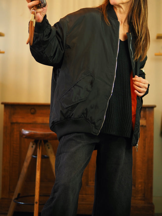 Bombers noir légèrement satiné intérieur orange. 
Taille S du 36 au 40 et M du 38 au 42. 
100% Coton.
S : Tour de poitrine 130cm Longueur dos 77cm. M : Tour de poitrine 134cm Longueur dos 77cm.