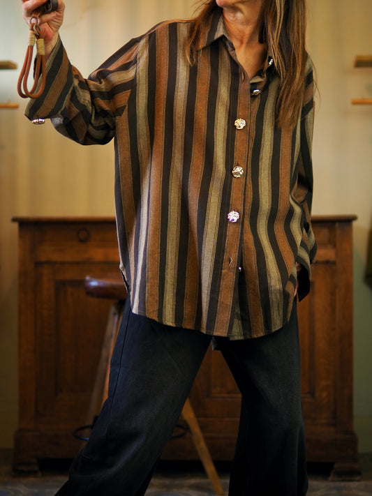 Chemise lignée marron camel. Boutons décoratifs dorés.
Taille unique convient du 36 au 42/44. 
80% Polyester 20% Coton.
Tour de poitrine 140cm Longueur dos 82cm.