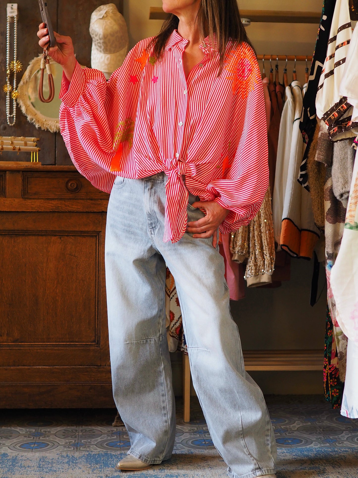 Chemise ample lignée rouge et blanc à nouer devant. Coupe chauve-souris. Broderies fluos.
100% Viscose.
Taille unique convient du 36 au 46.
Longueur dos 60cm.