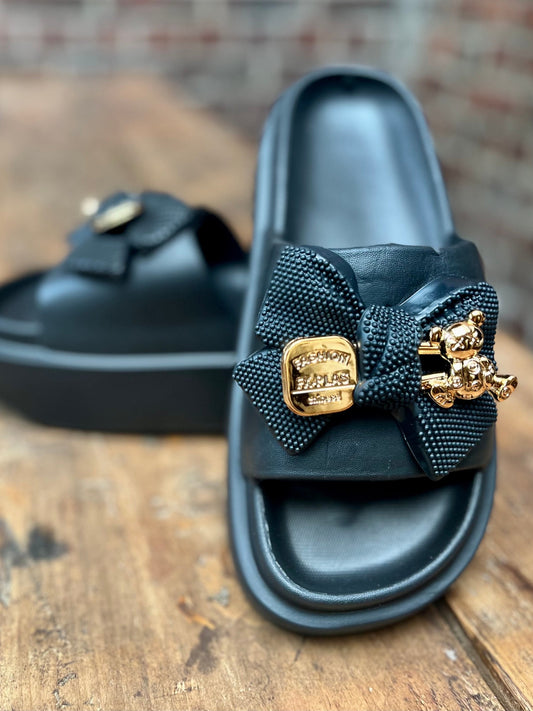 Mules noires, noeuds avec Pin's dorés. Très originales et confortables. Taille normal. Hauteur semelle 4,5cm. Du 36 au 41.