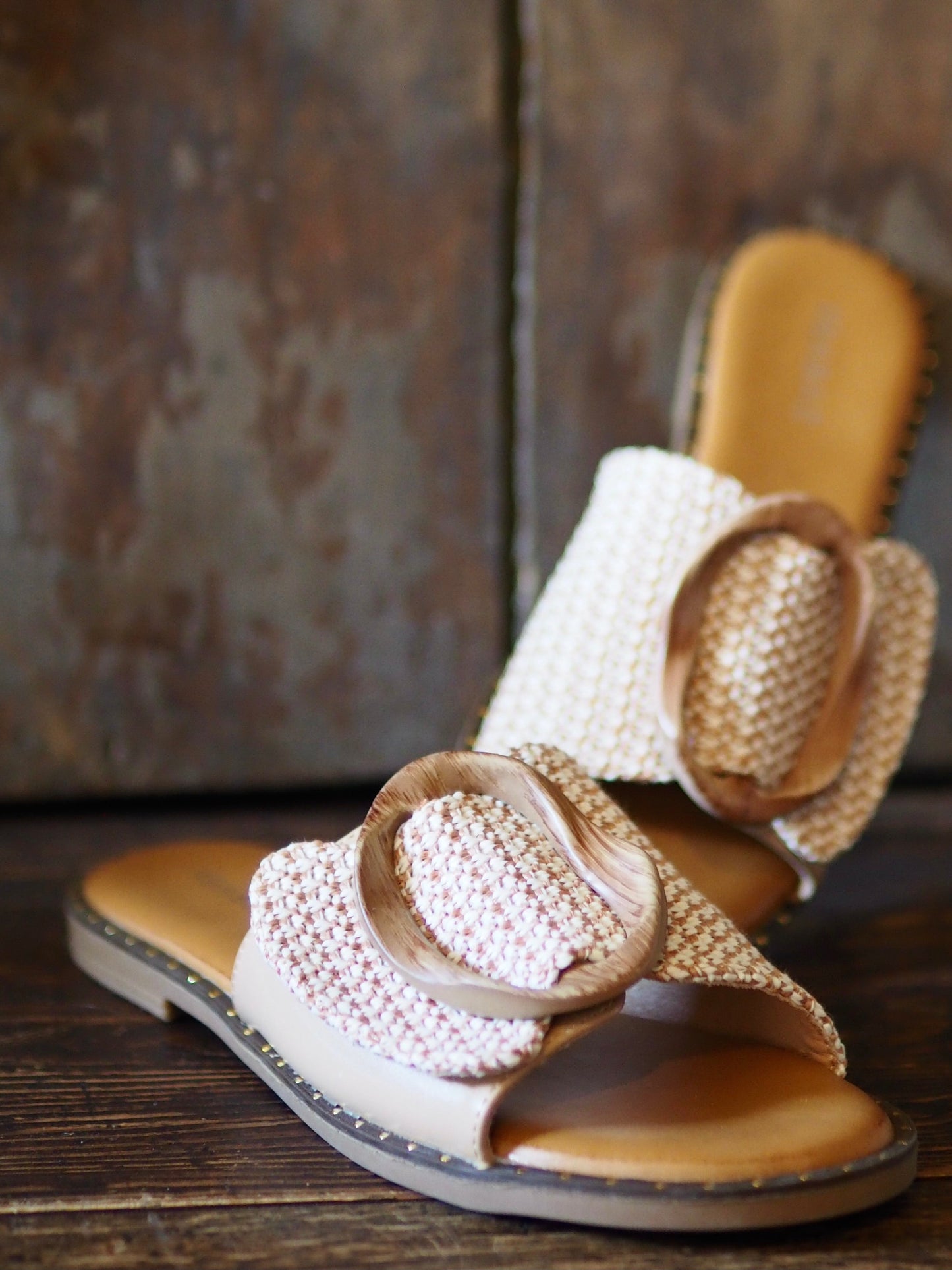 Mules plates beiges et partie tressée beige/camel avec le détail de la boucle en bois qui fait sa beauté. Petit coussin sur la semelle qui la rend confortable.
Hauteur talon 1,5cm.
Taille normal mais si entre 2 pointures prendre la pointure au dessus.