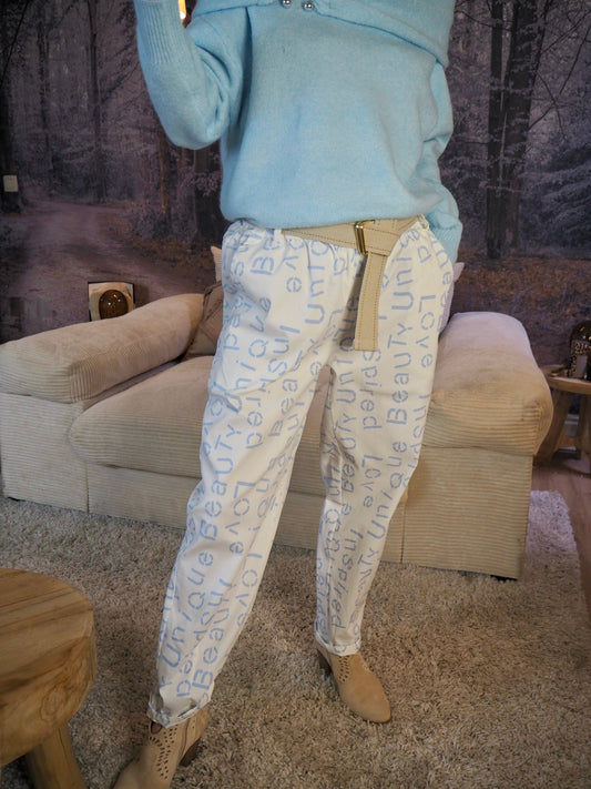 Pantalon blanc avec inscriptions bleus ciel. Taille élastique avec ceinture réglable. 77% Viscose 18% Polyamide 5% Elastane. Taille Unique. Largeur max de tour de taille 116cm.