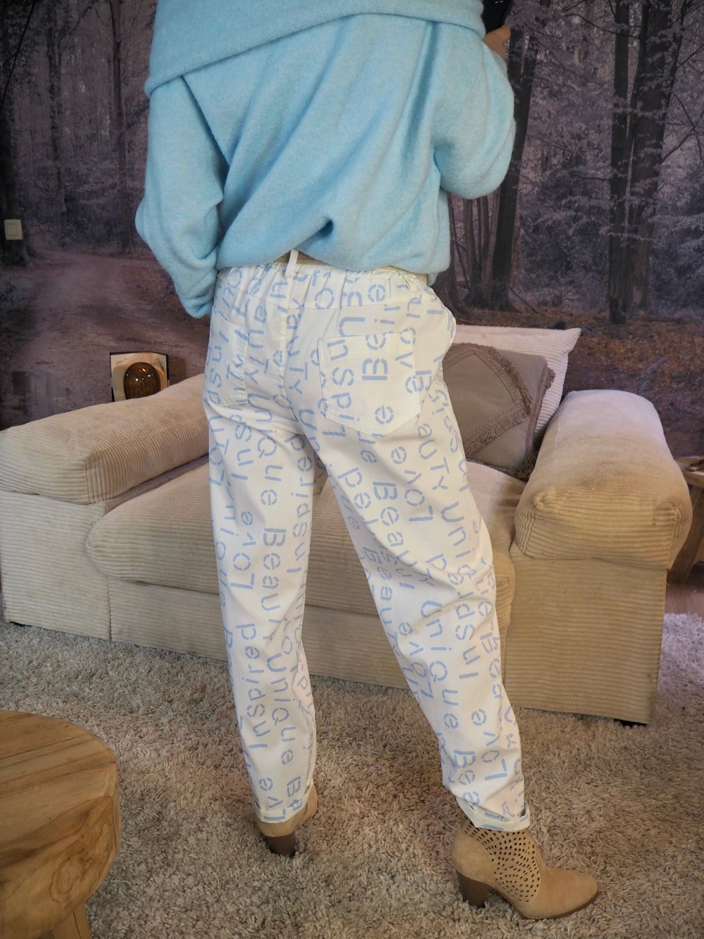 Pantalon blanc avec inscriptions bleus ciel. Taille élastique avec ceinture réglable. 77% Viscose 18% Polyamide 5% Elastane. Taille Unique. Largeur max de tour de taille 116cm.