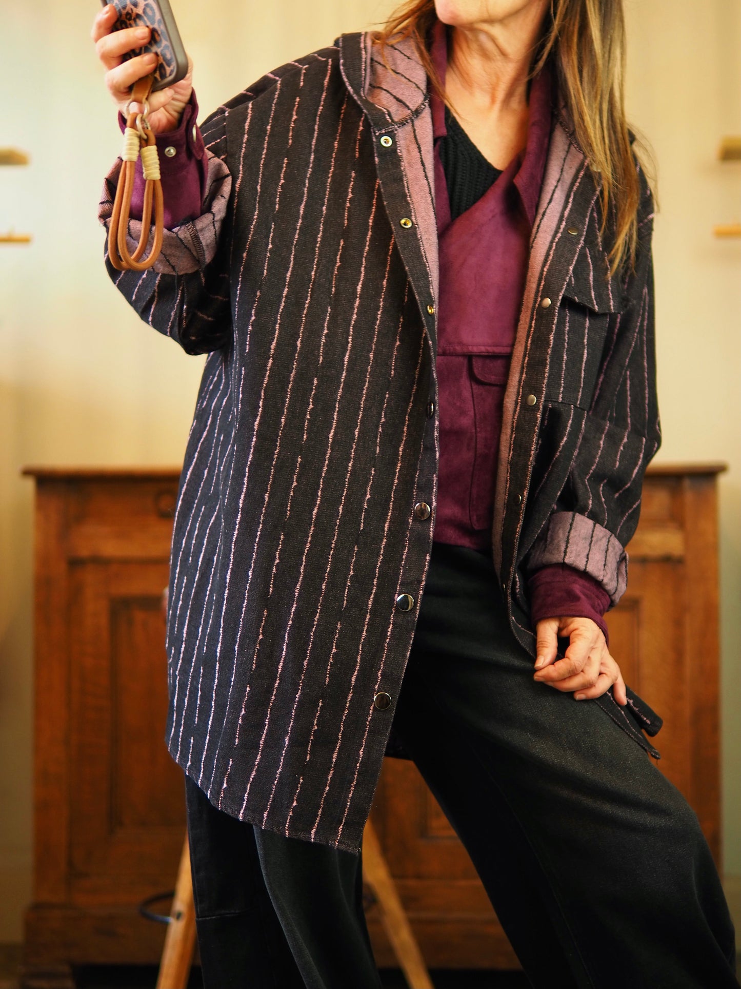 Veste chemise jeans noir avec une fine ligne irrégulière vieux rose. Boutons pressions et capuche.
Taille unique convient du 36 au 46.
75% Coton 25% Polyester.
Tour de poitrine 148cm Longueur dos 85cm.
