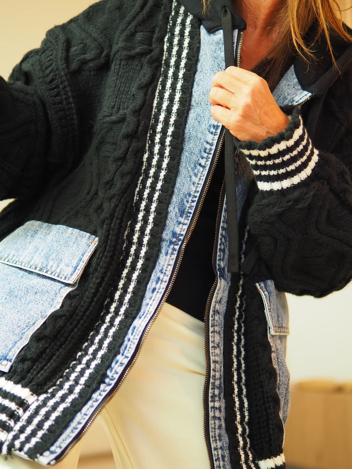 Veste/gilet grosse maille noire et jeans. Capuche. Tirette avant.