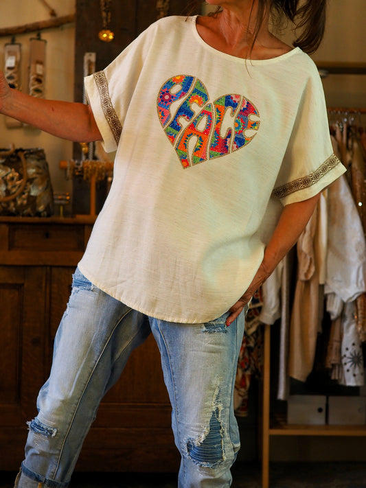 Blouse écru/beige avec écusson coeur coloré et doré.

100% Viscose .
Taille unique convient du 36 au 42.
Tour de poitrine 130cm Longueur dos 67cm.
