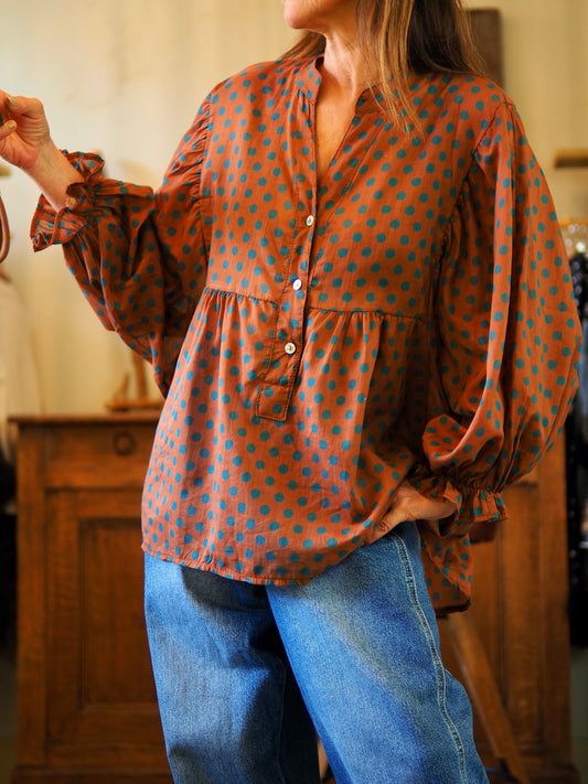 Blouse en voile de coton rouille avec pois bleu canard. Manches bouffantes.

Taille unique convient du 36 au 44.
100% Coton.
Tour de poitrine 150cm Longueur dos 75cm.