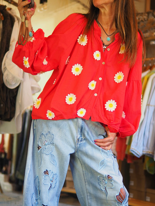Blouse rouge fluide ornée de marguerites, avec manches longues légèrement bouffantes et fermeture boutonnée. Une pièce lumineuse et féminine pour un look frais et tendance.

Taille unique du 36 au 46.
100% Coton.
Tour de poitrine 154cm Longueur dos 58cm.