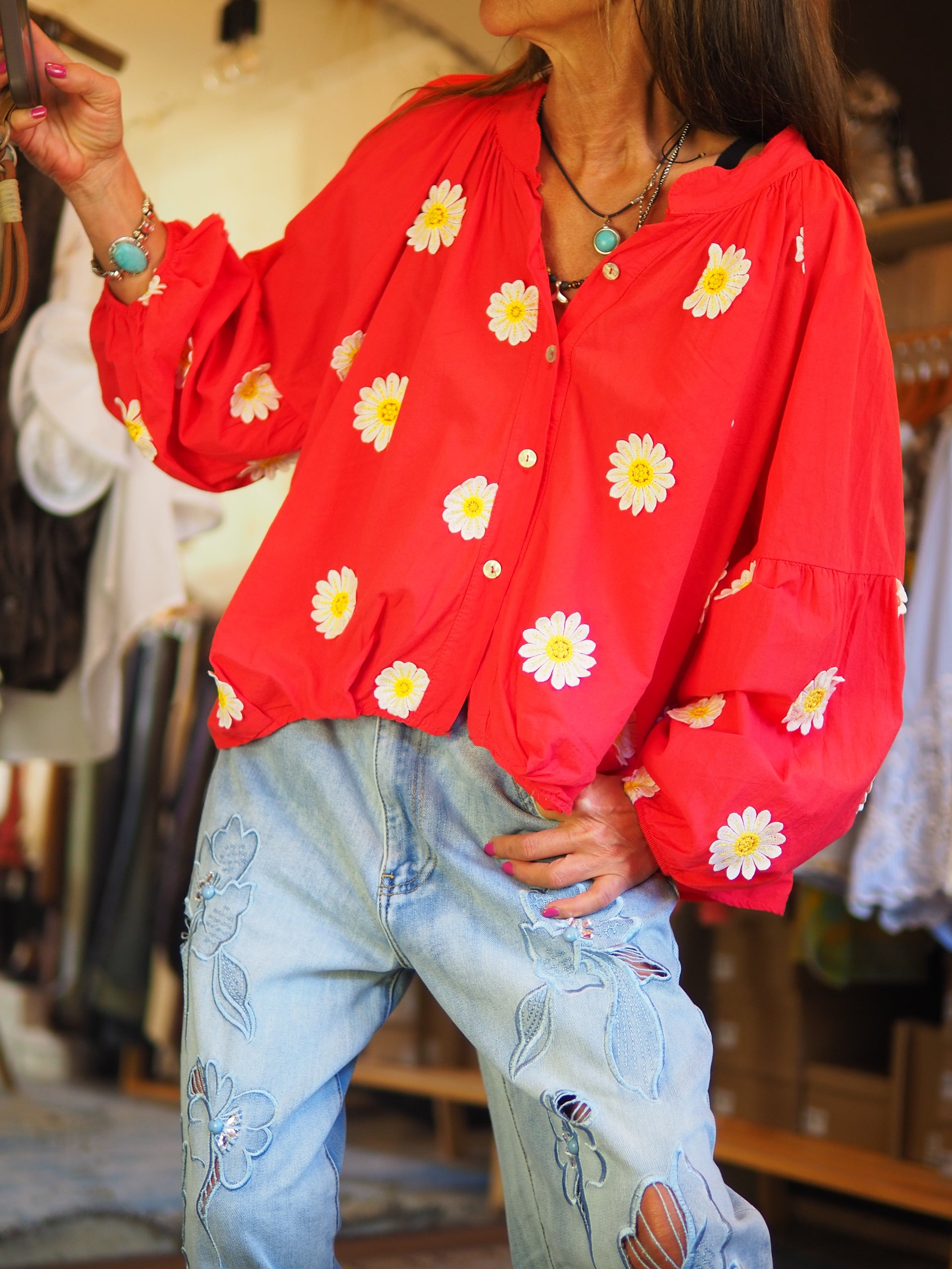 Blouse rouge fluide ornée de marguerites, avec manches longues légèrement bouffantes et fermeture boutonnée. Une pièce lumineuse et féminine pour un look frais et tendance.

Taille unique du 36 au 46.
100% Coton.
Tour de poitrine 154cm Longueur dos 58cm.