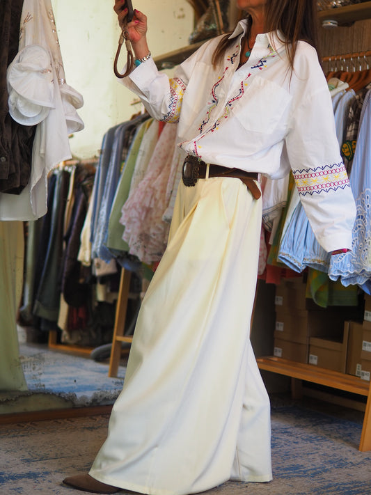 Chemise blanche à coupe classique, sublimée par des broderies colorées. Élégante et originale, parfaite pour un look chic avec une touche bohème.

Taille unique du 36 au 40/42.
98% Coton 2% Polyester.
Tour de poitrine 116cm Longueur dos 74cm.