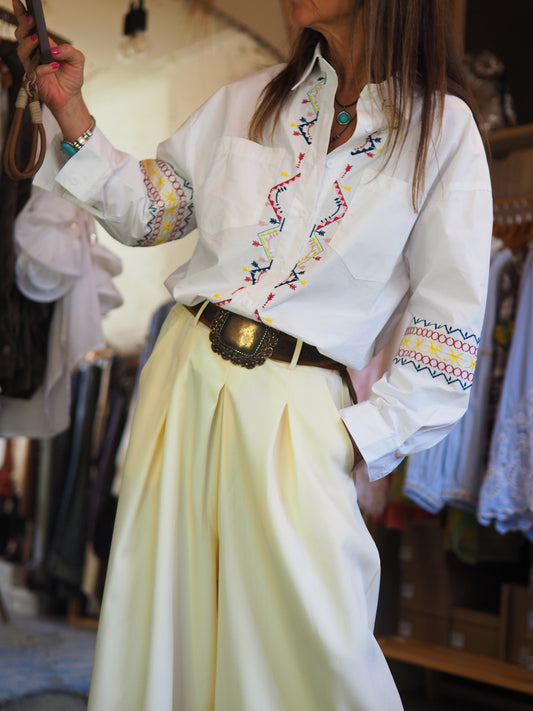 Chemise blanche à coupe classique, sublimée par des broderies colorées. Élégante et originale, parfaite pour un look chic avec une touche bohème.

Taille unique du 36 au 40/42.
98% Coton 2% Polyester.
Tour de poitrine 116cm Longueur dos 74cm.