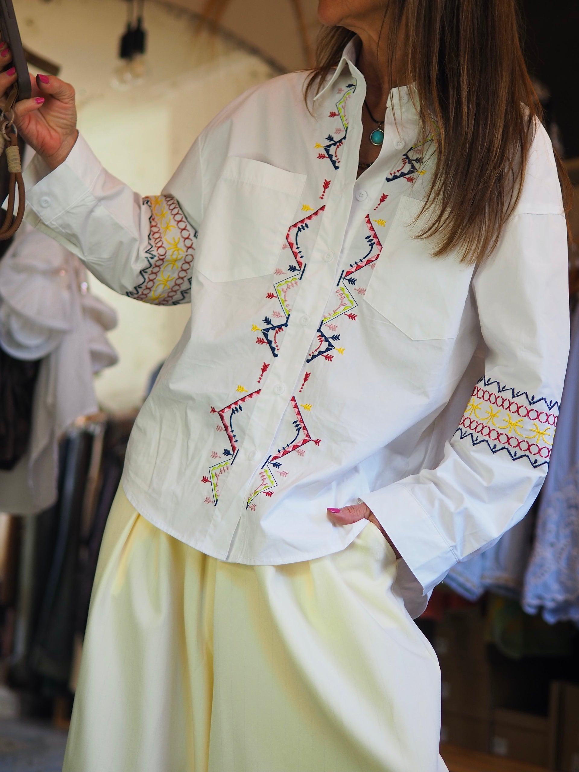 Chemise blanche à coupe classique, sublimée par des broderies colorées. Élégante et originale, parfaite pour un look chic avec une touche bohème.

Taille unique du 36 au 40/42.
98% Coton 2% Polyester.
Tour de poitrine 116cm Longueur dos 74cm.