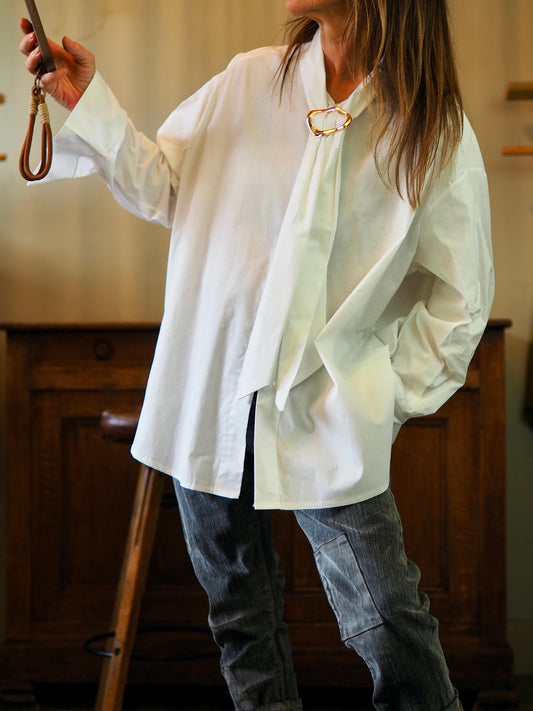 Chemise blanche avec col cravate retunue par un rond metal doré.

Taille unique convient du 36 au 44/46.
100% Coton.
Tour de poitrine 148cm Longueur dos 84cm. 