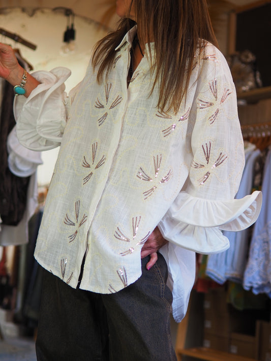 Chemise écru fluide ornée de broderies et sequins délicats, avec manches à volants. Élégante et raffinée, parfaite pour illuminer une tenue chic.

Taille unique du 36 au 44.
100% Coton.
Tour de poitrine 126cm Longueur dos 83cm.
