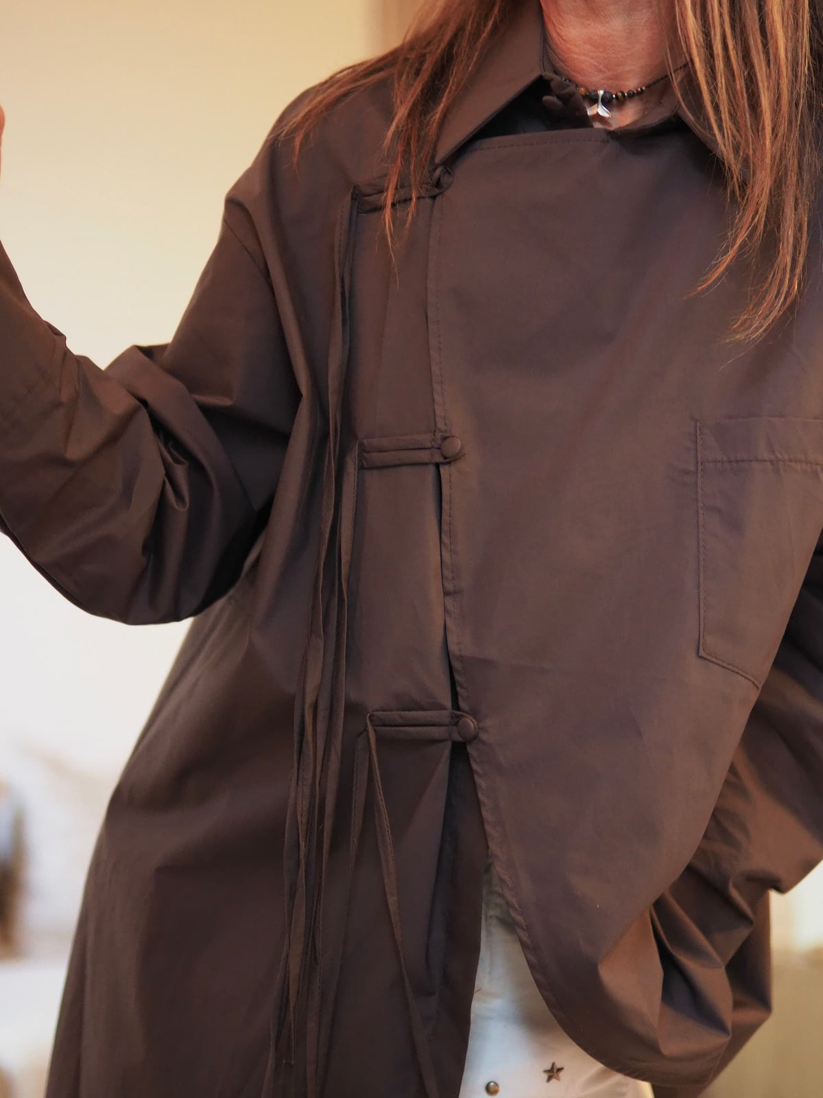 Chemise marron destructurée fermée par de boutons cotés avec cordon.