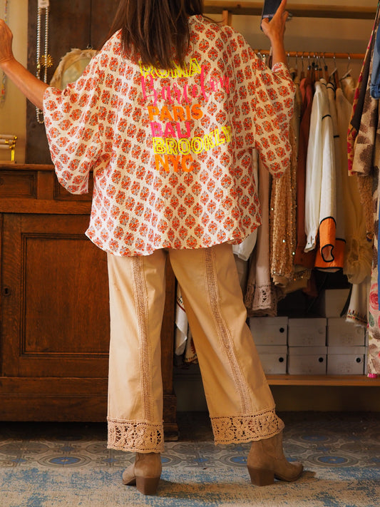 Blouse fluide dans les tons orangés avec inscriptions fluos dans le dos. Une pépite..

85% Tencel 15% Nylon.
Taille unique convient du 36 au 46.
Tour de poitrine 196cm Longueur dos 65cm.