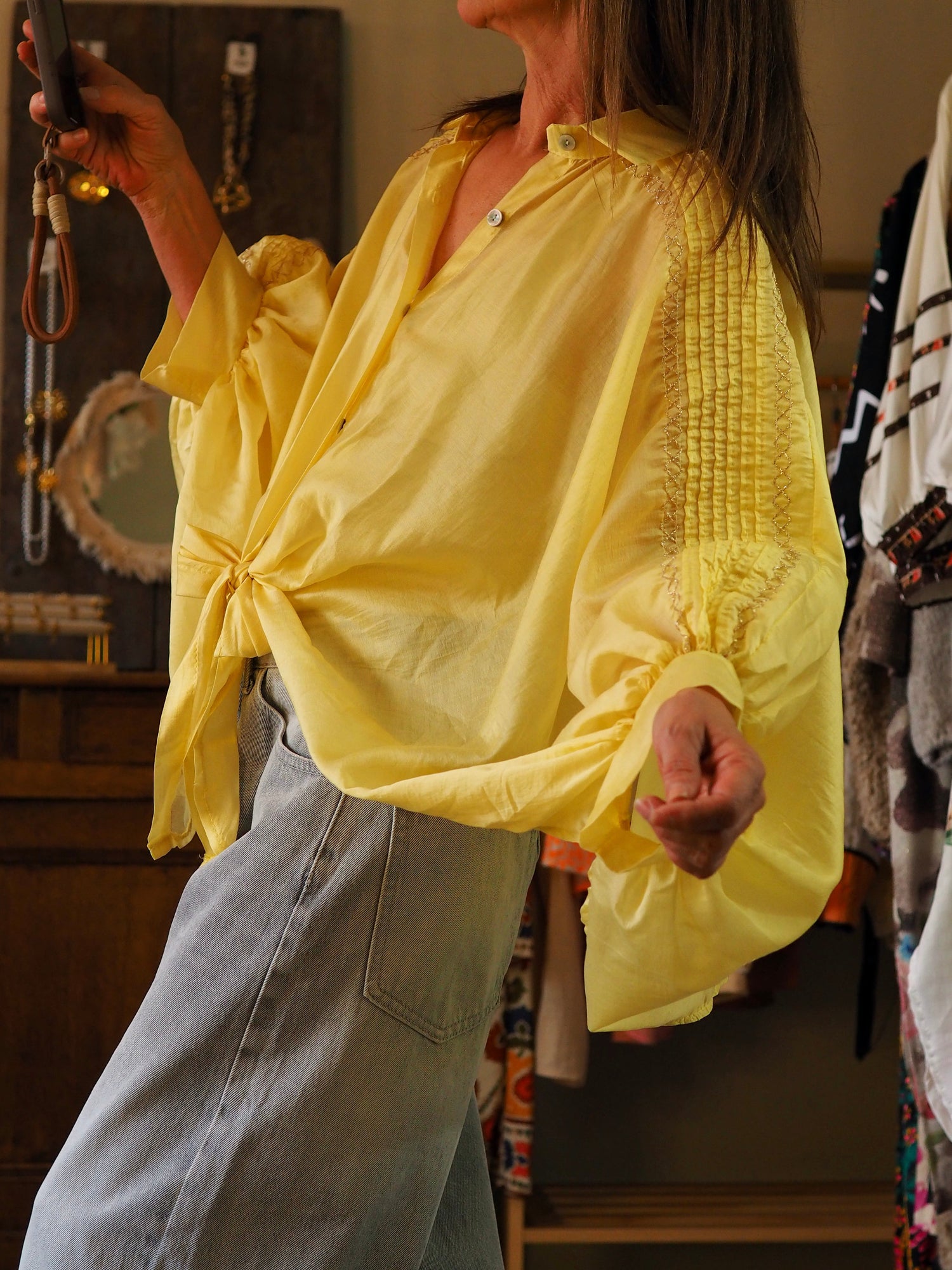 Chemise ample jaune à nouer devant. Coupe chauve-souris. Fils dorés sur les manches.

85% Tencel 15% Polyester.
Taille unique convient du 36 au 46.
 Longueur dos 60cm.