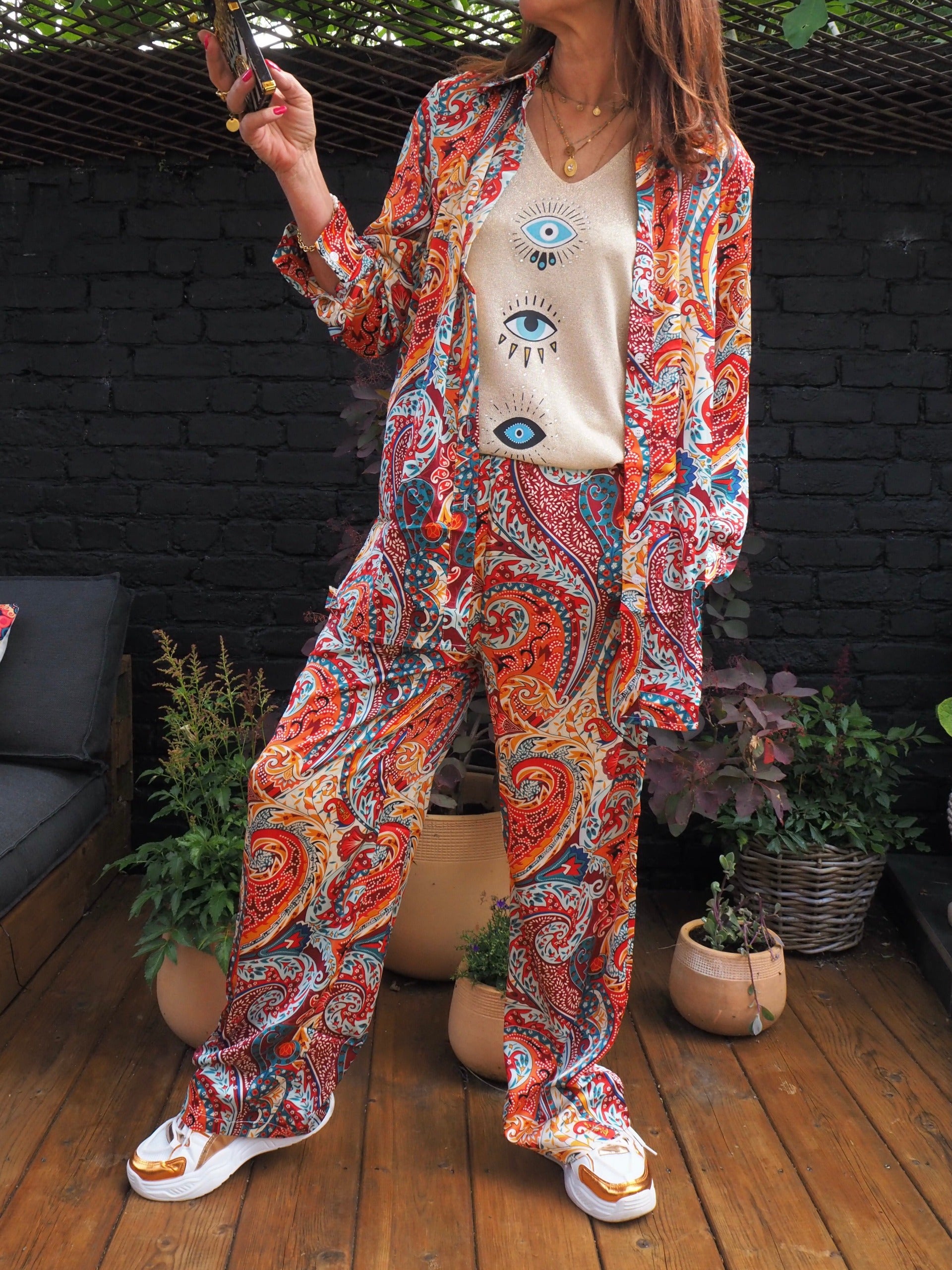 Ensemble fluide satiné dans les tons rouges. Pantalons élastique à la taille, chemise boutonnée... très agréable à porter.  100% Polyester. Taille S/36 M/38 L/40. Cathy mesure 1m66 fait un 36 et porte une taille S.