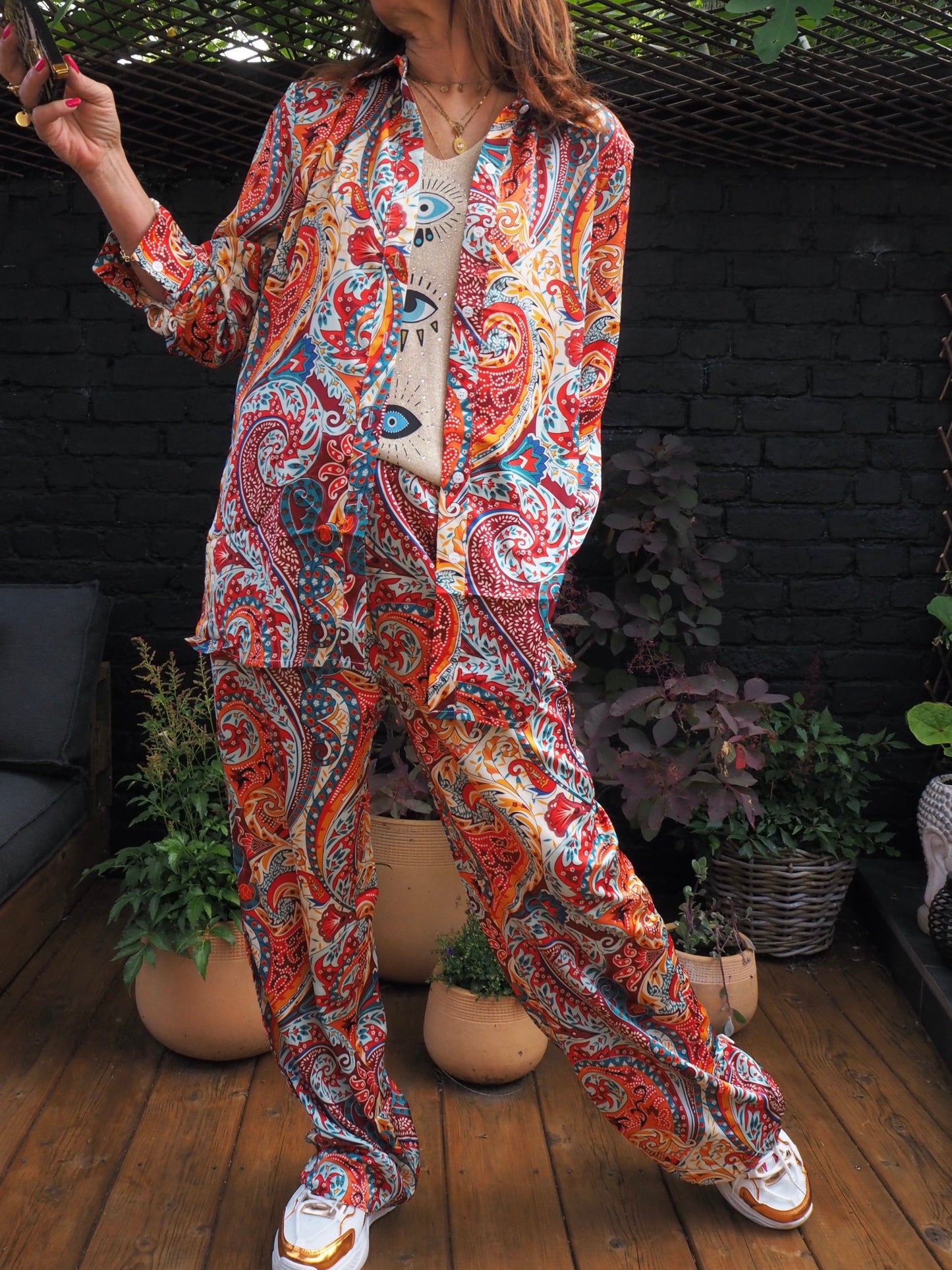 Ensemble fluide satiné dans les tons rouges. Pantalons élastique à la taille, chemise boutonnée... très agréable à porter.  100% Polyester. Taille S/36 M/38 L/40. Cathy mesure 1m66 fait un 36 et porte une taille S.