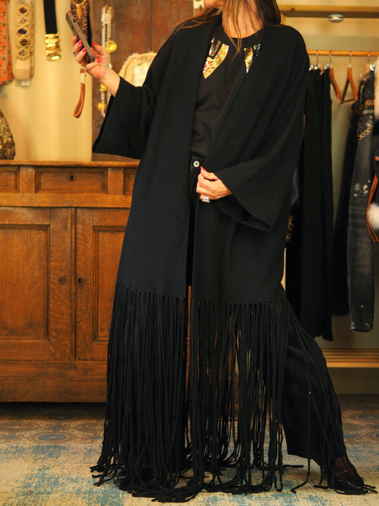 Gilet noir avec franges dans le bas. Super qualité. Assez long pour moi donc je l'ai porté avec une ceinture mais les franges peuvent être coupées facilement à la longueur voulue.

Taille unique convient du 36 au 46.
50% Viscose 28% Polyester 22% Nylon.
Largeur dos 70cm.