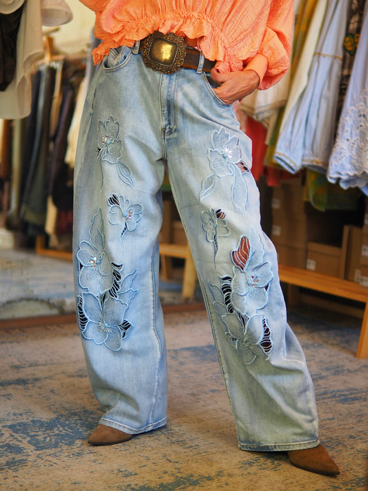 Jean large en denim clair, décoré de grandes broderies florales et perles, avec détails ajourés. Coupe tendance et confortable, parfait pour un look bohème et original. Taille grand, je porte un S mais avec ceinture.

Taille S/38 M/40 L/42.
70% Coton 27% Polyester 3% Elasthane.
S : Tour de taille 84cm. M : Tour de taille 90cm. L : Tour de taille 94cm.