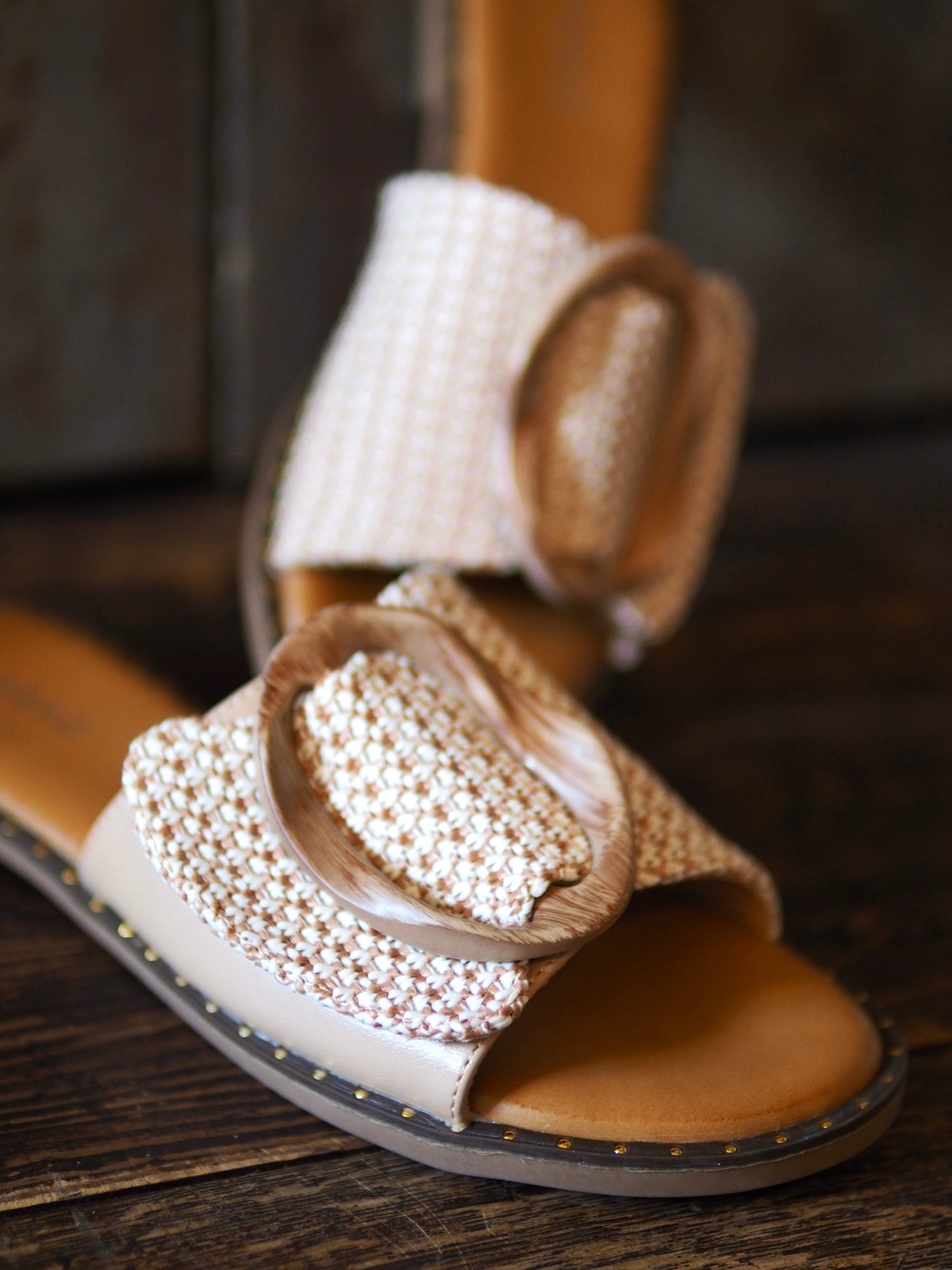 Mules plates beiges et partie tressée beige/camel avec le détail de la boucle en bois qui fait sa beauté. Petit coussin sur la semelle qui la rend confortable. 

Hauteur talon 1,5cm.
Taille normal mais si entre 2 pointures prendre la pointure au dessus.