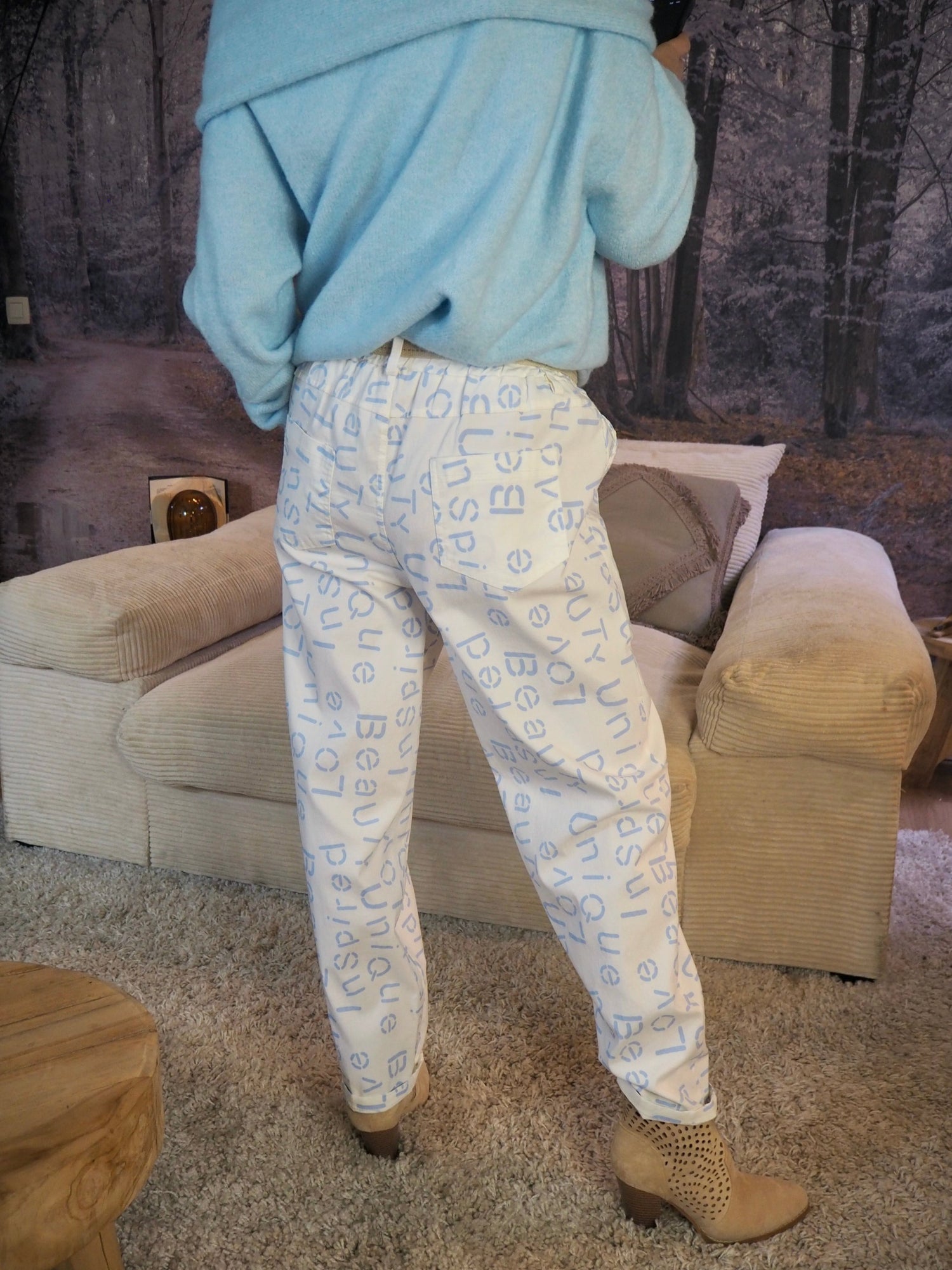 Pantalon blanc avec inscriptions bleus ciel. Taille élastique avec ceinture réglable. 77% Viscose 18% Polyamide  5% Elastane. Taille Unique. Largeur max de tour de taille 116cm.