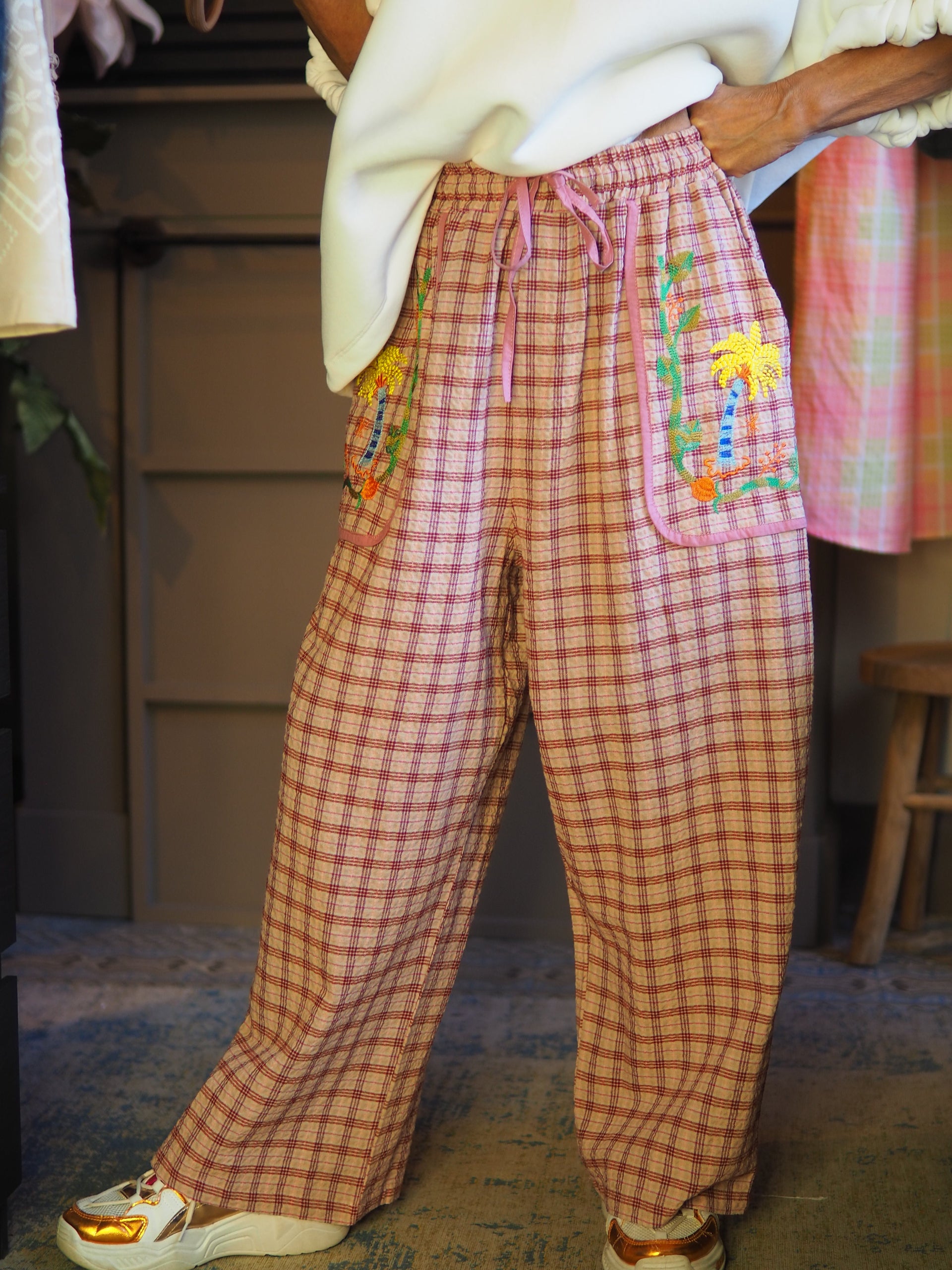Taille unique convient du 36 au 42.

Mesures : Tour de taille maximum 110cm.
Composition : 47% Coton 33% Viscose 13% Polyester 7% Autres fibres.
Cathy mesure 1m66 fait un 36 et porte une taille unique.


Pantalon carreaux dans les tons rose et rouge. Broderies sur les poches avants. Taille élastique.
