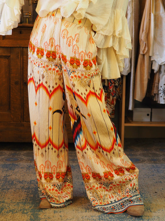 Pantalon fluide dans les tons beiges et orangés. Boutonné à l'avant et tirette avecdos élastique.

86% Viscose 14% Polyamide.
Taille S/M:36/38 et M/L:38/40(petit 42).