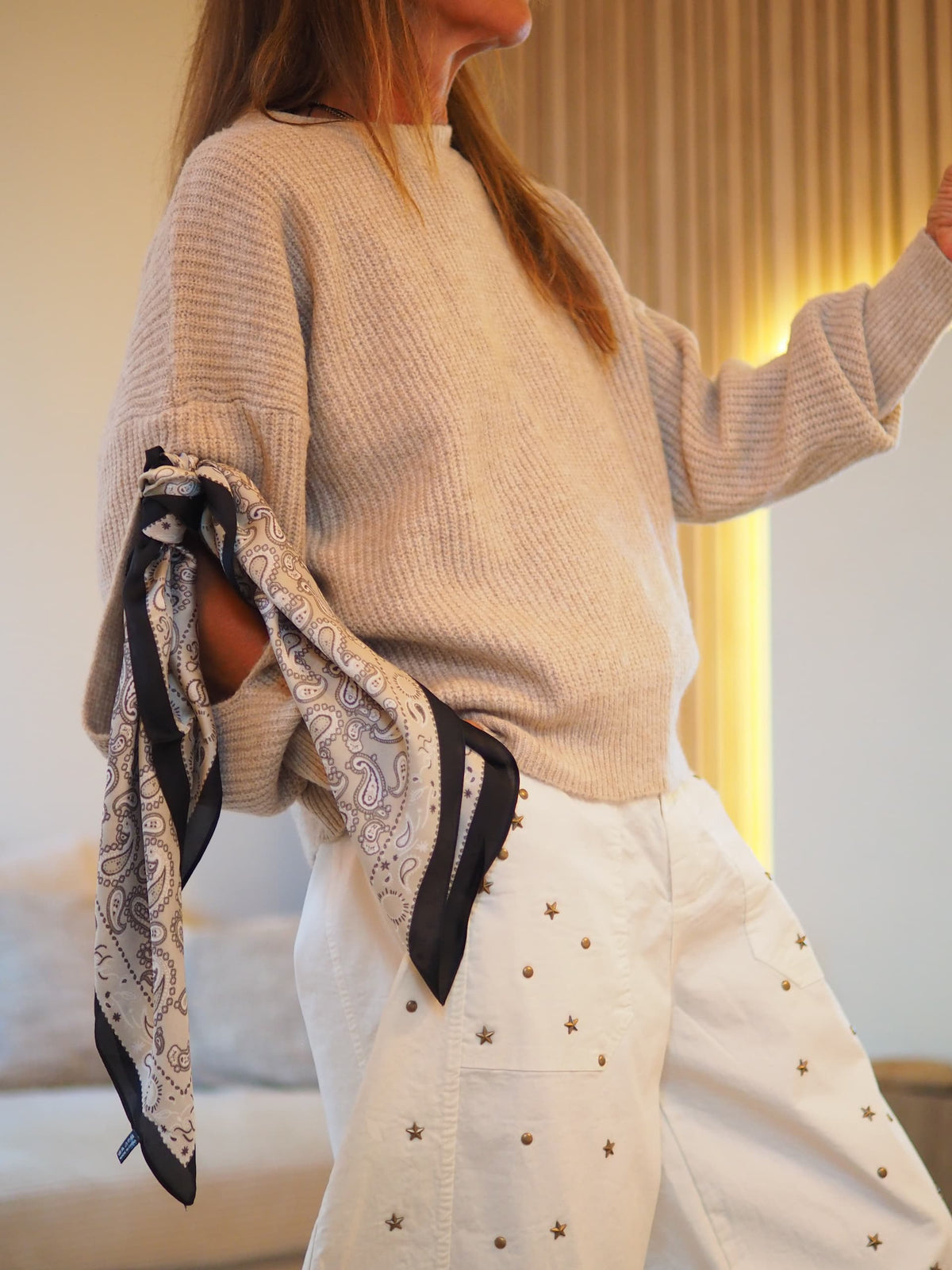 Pull beige foulard accroché à la manche.