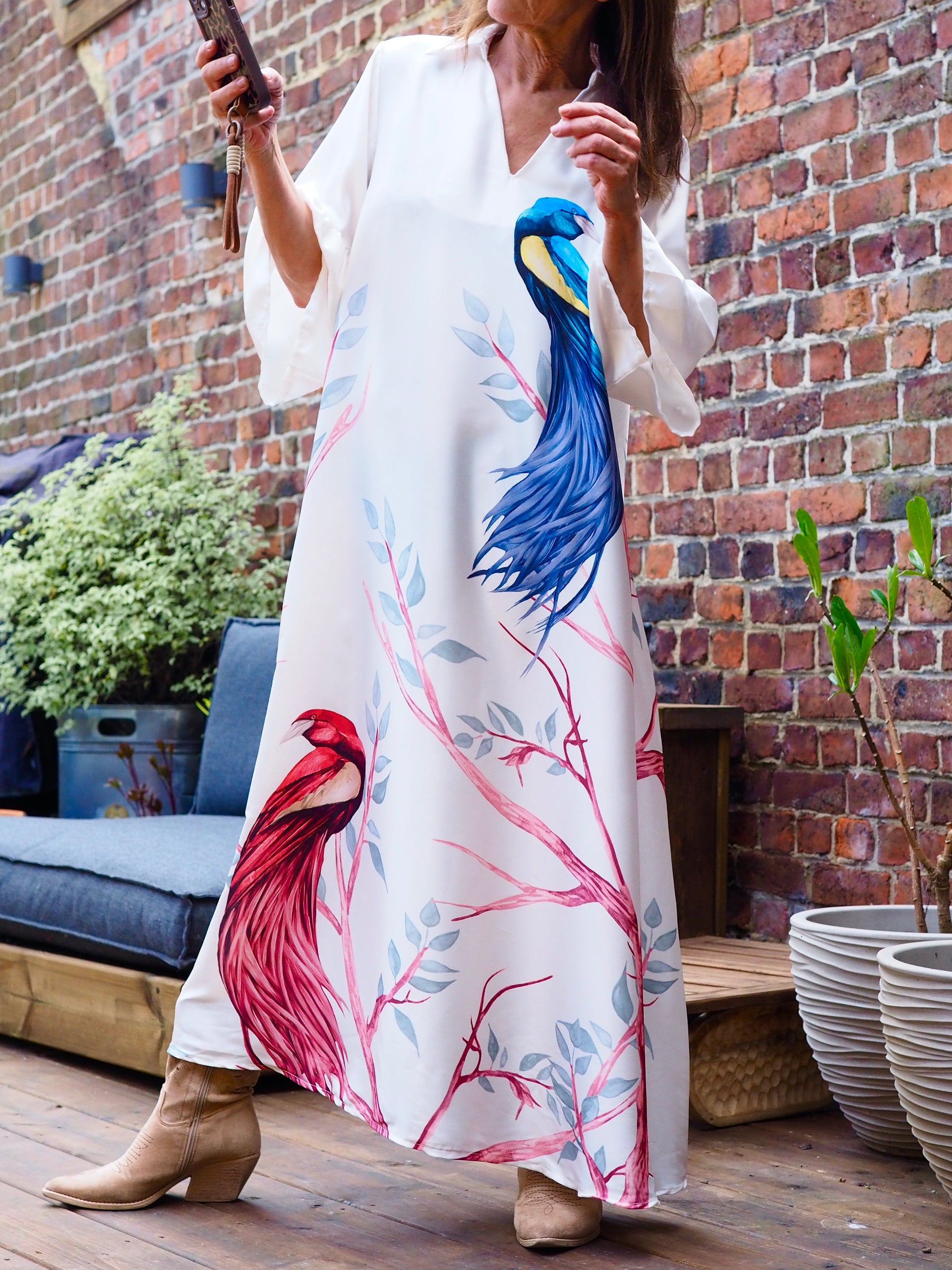 Robe effet satin blanche avec motifs. Manches volants.

100% Polyester. 
Taille unique convient du 36 au 42.
Tour de poitrine 116cm Longueur dos 132cm.