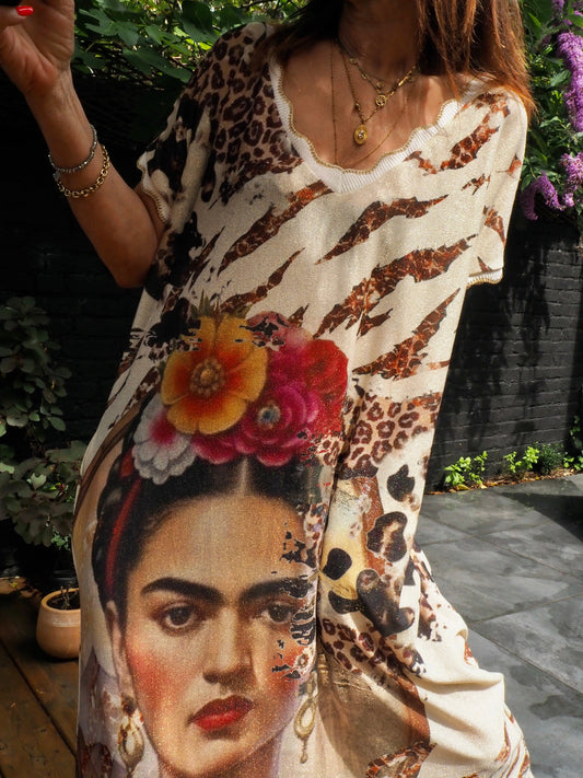 Robe lurex doré motifs Frida Khalo. Col V. 2 poches coté.  70% Viscose 25% Nylon 5% Elastane. Taille unique du 36 au 44. Tour de poitrine 130cm.