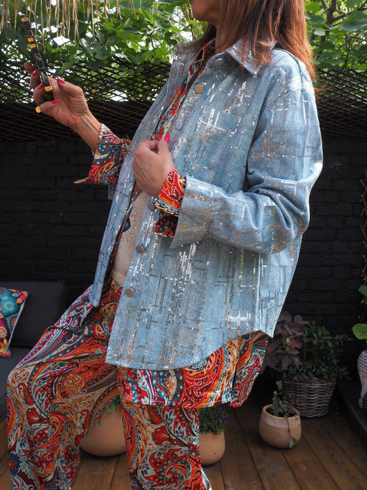 Veste en coton bleu clair avec sequins argentés. Pour briller au soleil..  80% Coton 20% Polyester. Taille S/36 M/38 L/40. Peut convenir à une taille supérieur.