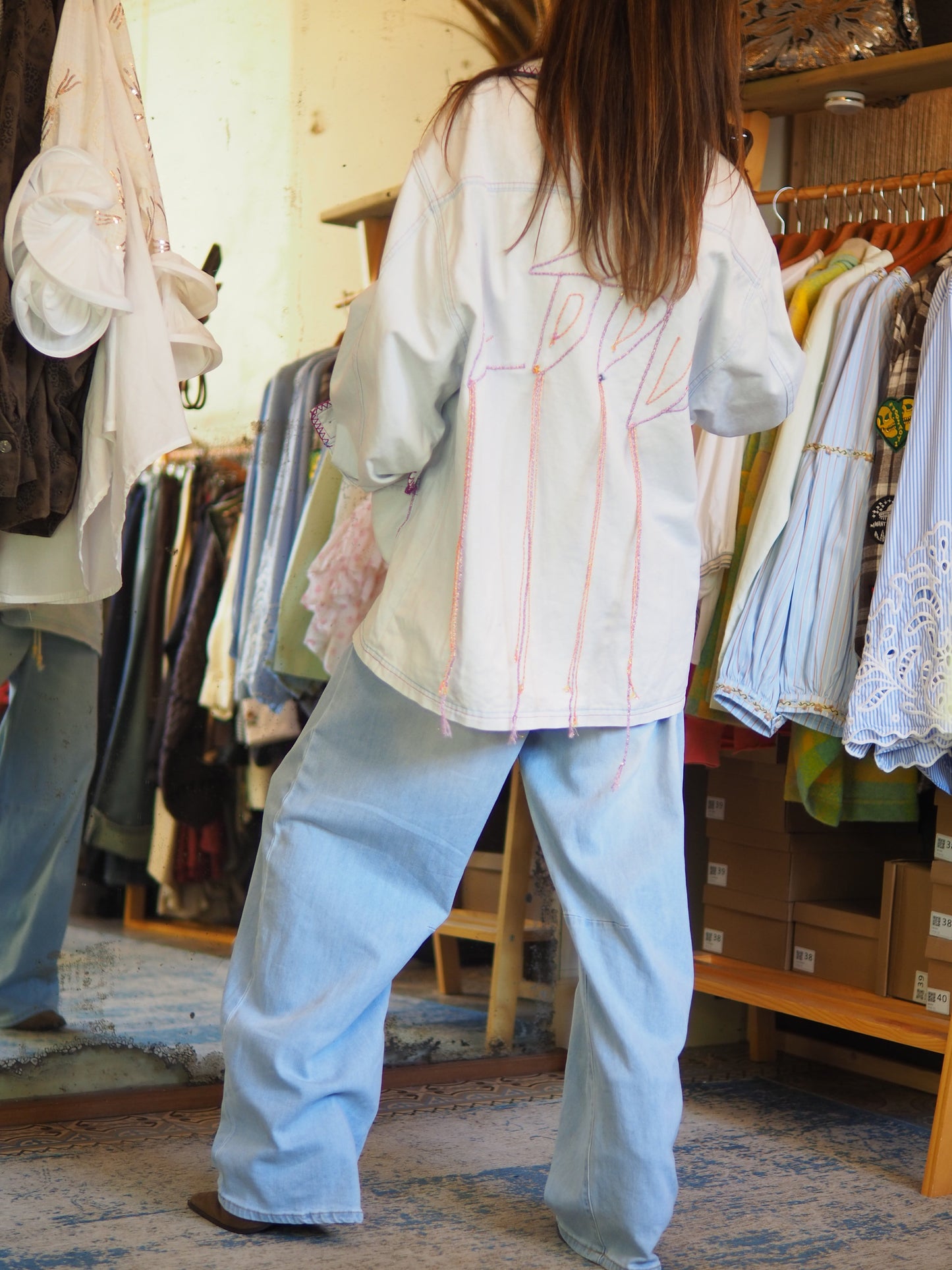 Veste oversize bleu clair avec broderies oranges et parmes au dos et finitions contrastées. Originale et tendance, parfaite pour twister un look casual.&nbsp;

Taille unique du 36 au 42/44.
90% Coton 10% Polyester.
Tour de poitrine 124cm Longueur dos 78cm.