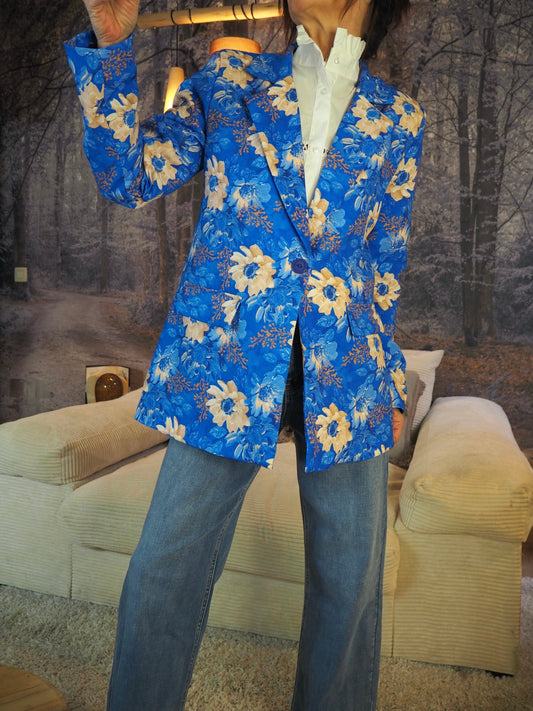Veste fleurie bleu roi avec doublure. Très peps. 100% Polyester. Taille Unique convient jusqu'au 42. Largeur aisselle à aisselle 54cm Longueur dos 73cm..