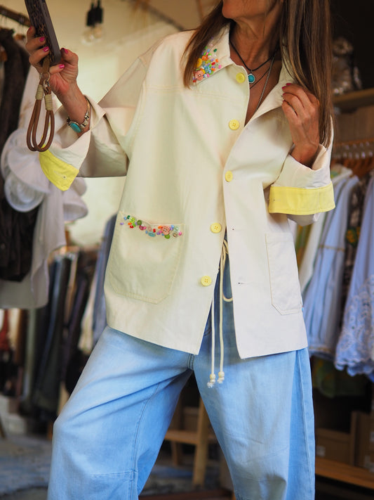 Veste oversize jaune pastel avec boutons ton sur ton et détails perlés colorés au col et à la poche. Doublée. Peut être portée en chemise.

Taille unique du 36 au 42/44.
70% Coton 30% Polyester.
Tour de poitrine 124cm Longueur dos 72cm.